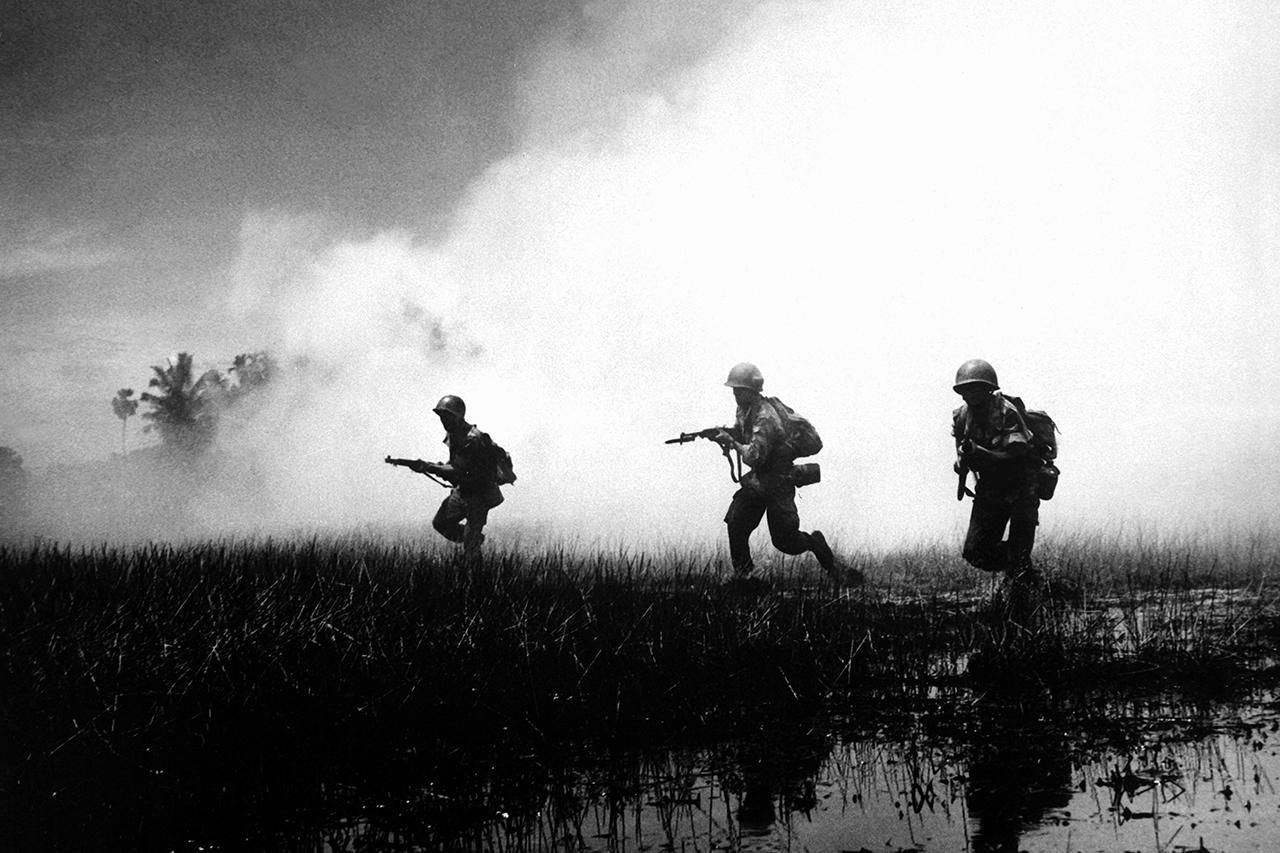 Gritty black and white photo of soldiers in battle